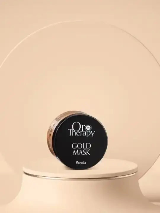 Oro Therapy Gold hydrating hair mask 300 ml on a minimalist display, showcasing its elegant packaging.